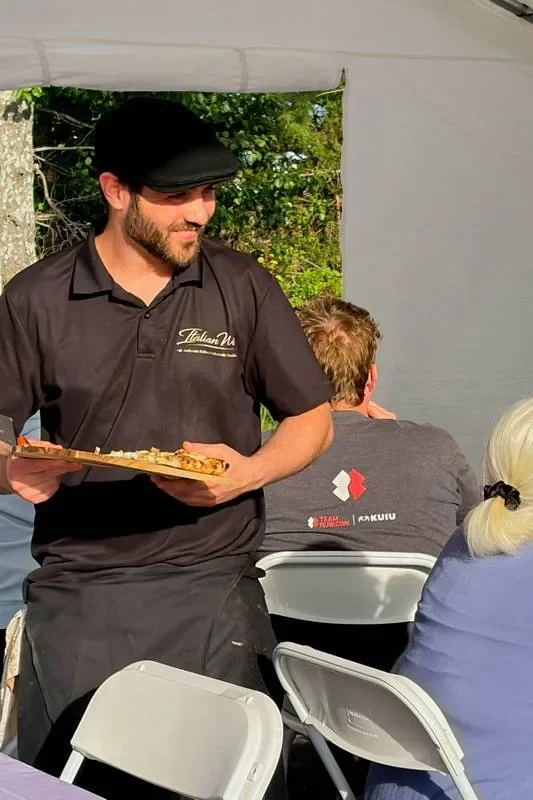 Italian Way chef serving pizza to guests at an outdoor event