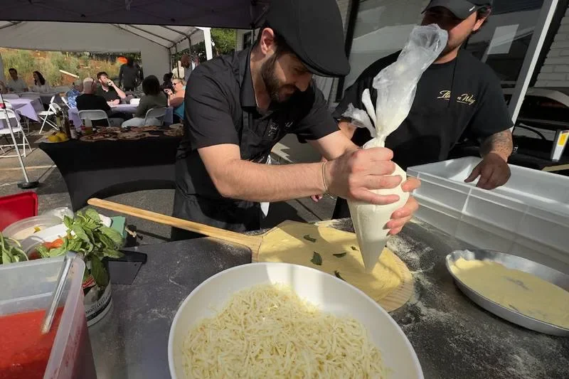 The chef preparing food by hand at a live catering event